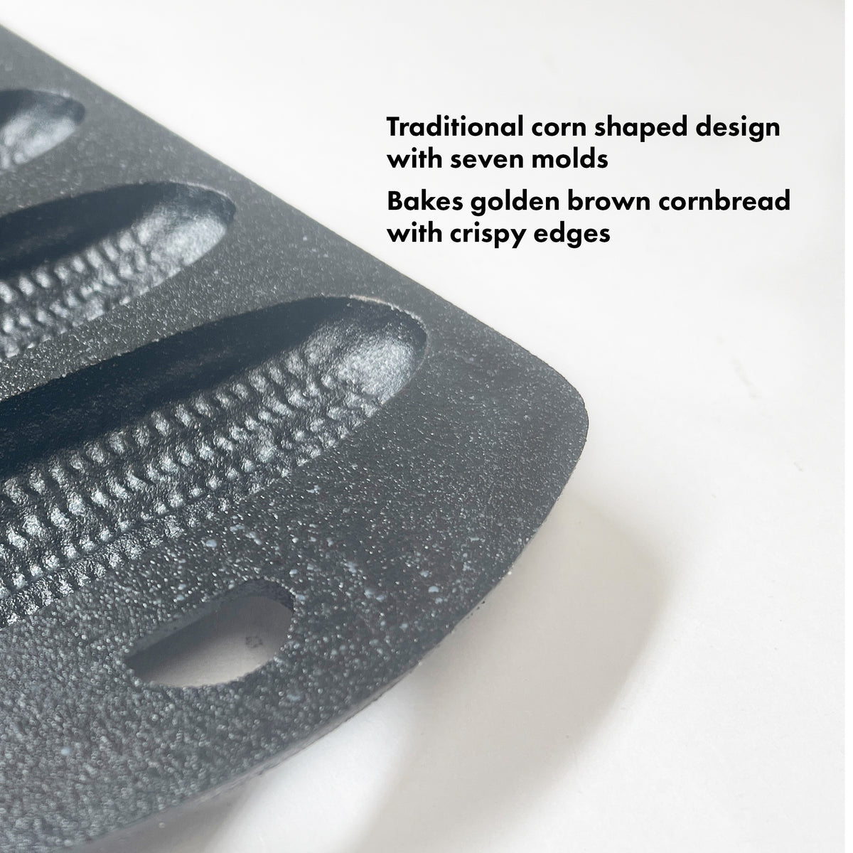 Close up image of cast iron cornbread pan on a white background. Features read traditional corn shaped design with seven molds. Bakes golden brown cornbread with crispy edges.
