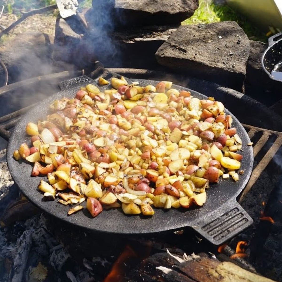 Fried potatoes in a cast iron discada over an open fire