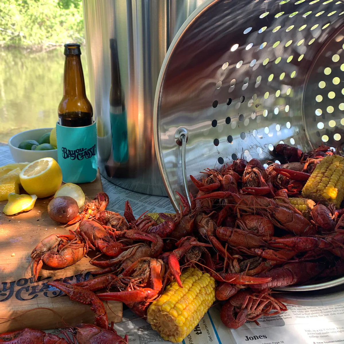 Stainless steel basket on table with crawfish and corn coming out