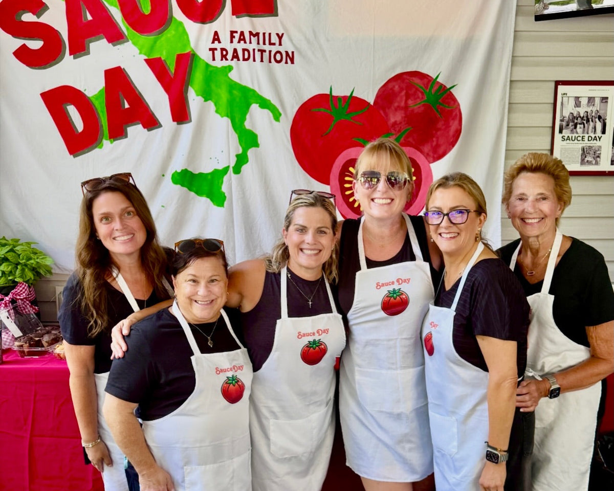 Ladies from a Sauce Day NJ event wearing aprons and smiling